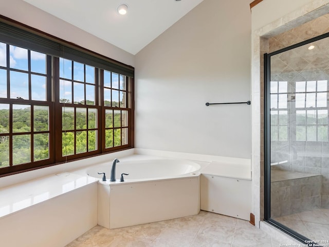 bathroom featuring shower with separate bathtub, tile patterned flooring, and vaulted ceiling