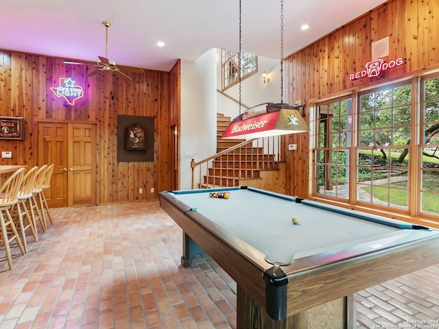 game room featuring billiards, a high ceiling, wooden walls, and ceiling fan