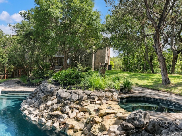 view of swimming pool featuring a yard