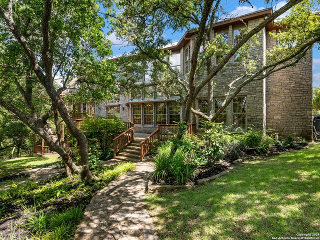 back of house featuring a deck and a yard