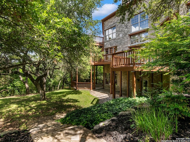 rear view of house with a deck and a lawn