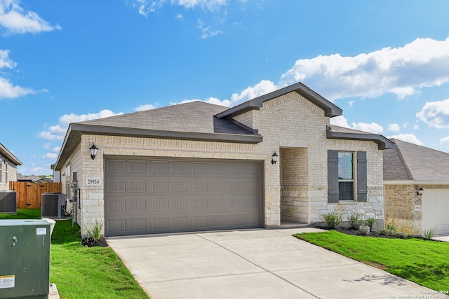 view of front facade with a garage, a front yard, and central air condition unit