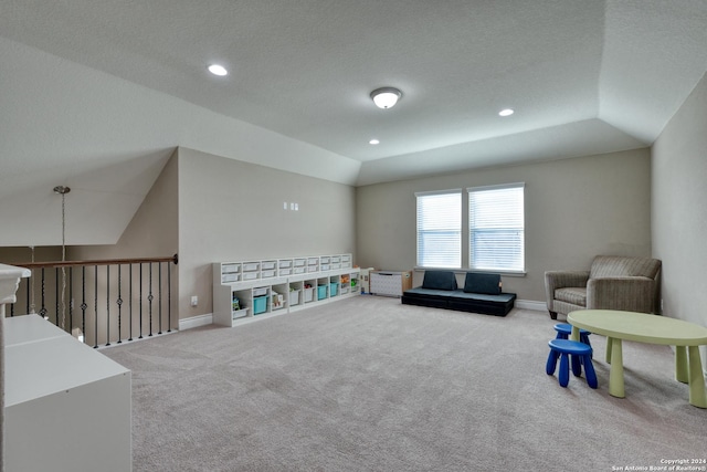 game room with a tray ceiling, a textured ceiling, carpet, and vaulted ceiling