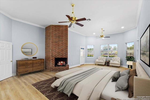 bedroom featuring light hardwood / wood-style floors, crown molding, a high ceiling, and a brick fireplace