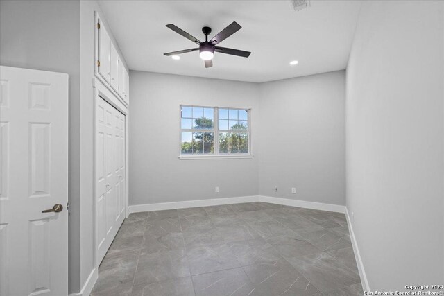 unfurnished bedroom with ceiling fan and a closet