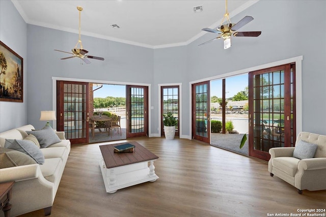 living room with ceiling fan, wood-type flooring, a high ceiling, and french doors