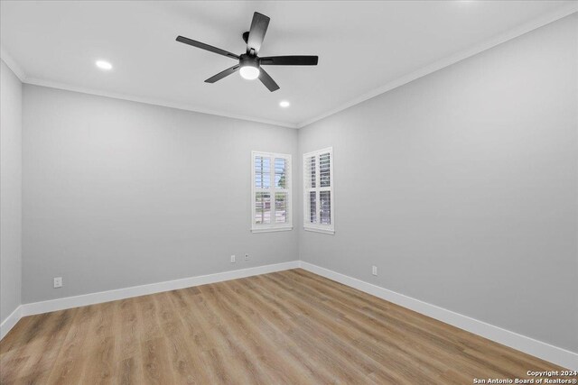 spare room with light wood-type flooring, ceiling fan, and ornamental molding