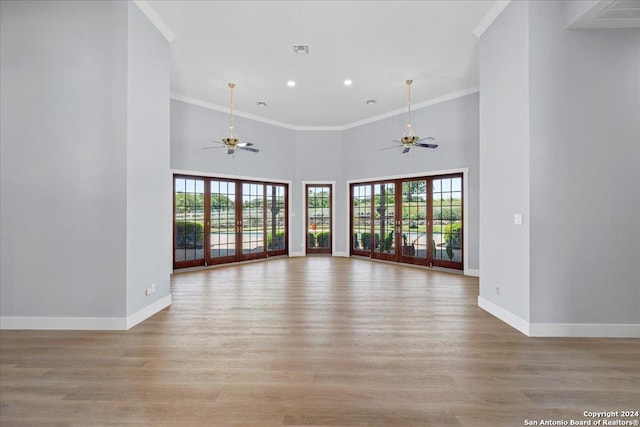 unfurnished living room featuring crown molding, a healthy amount of sunlight, and light wood-type flooring