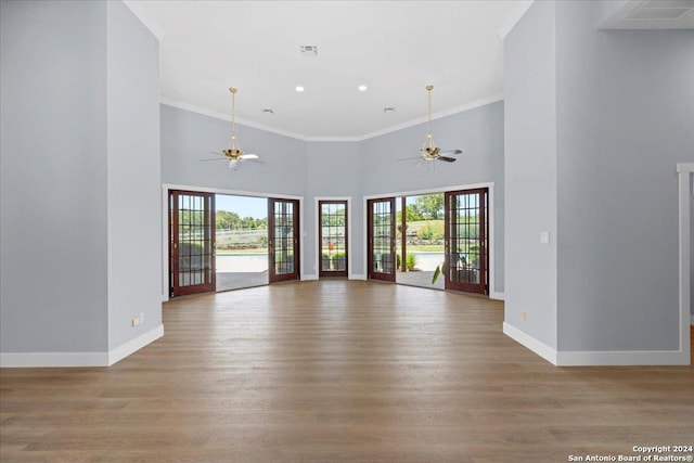 interior space with crown molding, light hardwood / wood-style floors, and a high ceiling