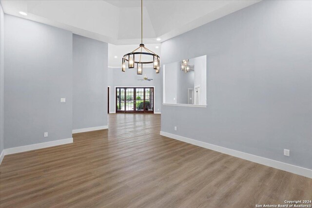 interior space with high vaulted ceiling, wood-type flooring, and an inviting chandelier