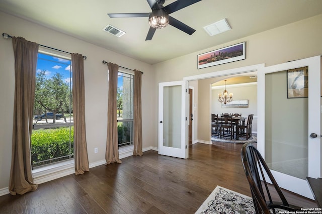 unfurnished office with dark hardwood / wood-style floors, ceiling fan with notable chandelier, and french doors