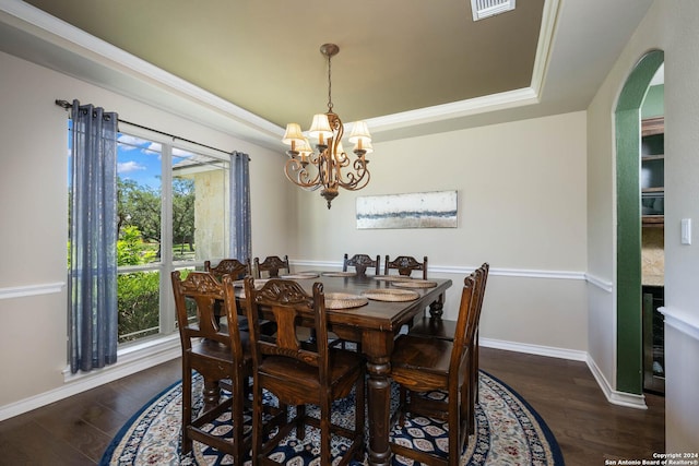 dining room featuring dark hardwood / wood-style floors, a raised ceiling, and a notable chandelier