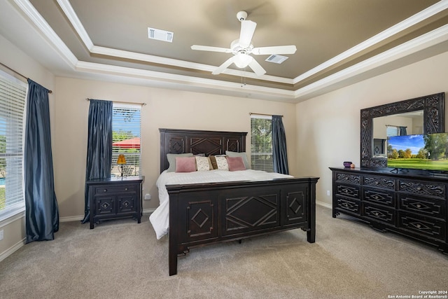 carpeted bedroom featuring ornamental molding, ceiling fan, and a tray ceiling