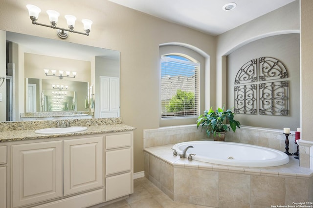 bathroom with vanity, a relaxing tiled tub, and tile patterned floors