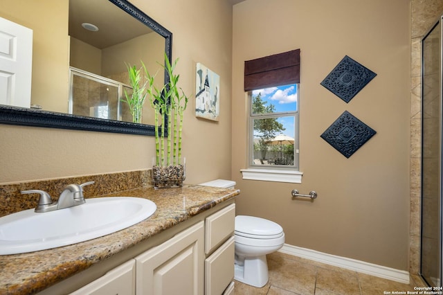 bathroom featuring vanity, toilet, a shower with shower door, and tile patterned flooring