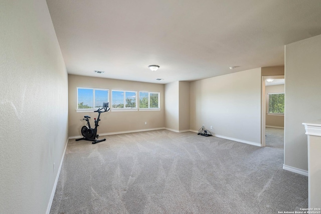 workout area with a healthy amount of sunlight and light colored carpet