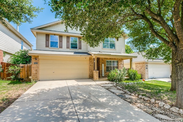 view of front facade featuring an attached garage, fence, brick siding, and driveway