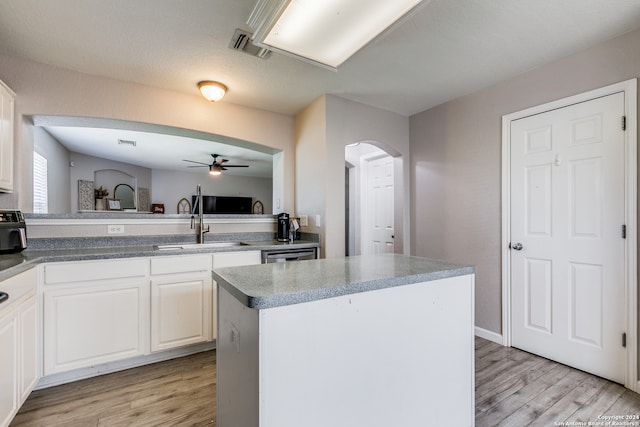 kitchen with white cabinetry, light hardwood / wood-style flooring, a center island, stainless steel dishwasher, and ceiling fan