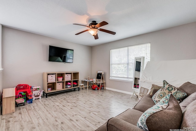 living area with wood finished floors, baseboards, and ceiling fan