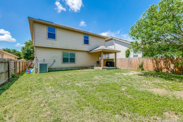 back of property featuring a lawn and central AC unit