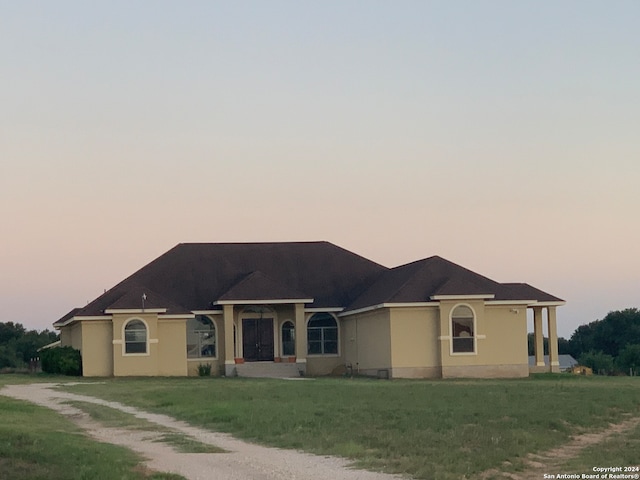 ranch-style home with a lawn