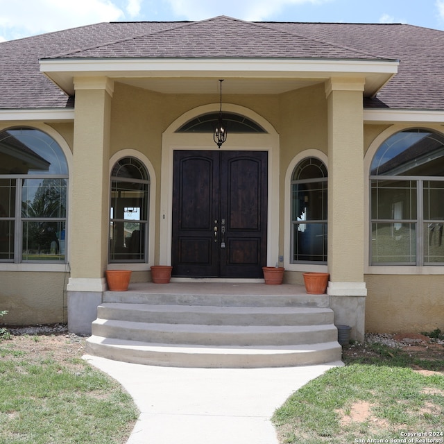 view of exterior entry featuring covered porch