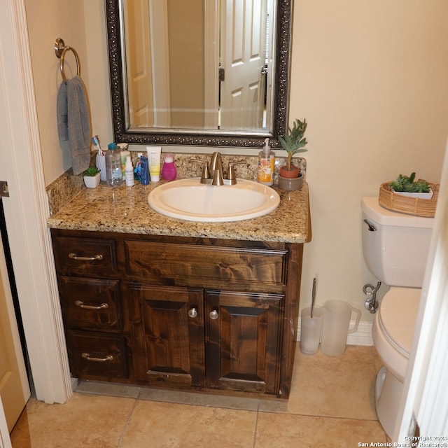 bathroom with vanity, tile patterned flooring, and toilet