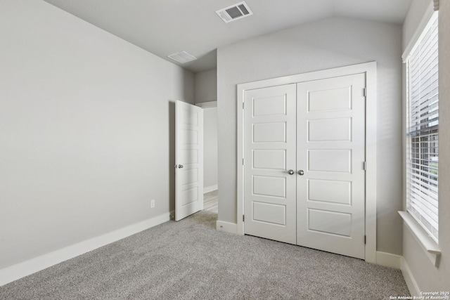 unfurnished bedroom with a closet and light carpet