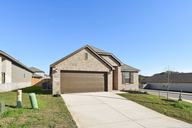 view of front of property with central AC unit, a garage, and a front lawn