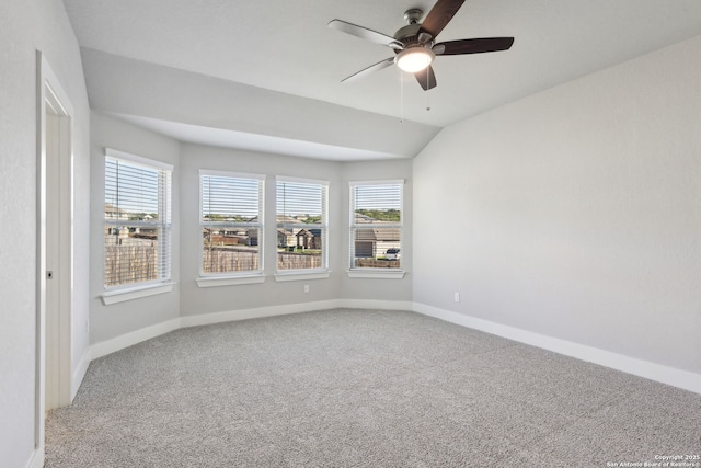 carpeted spare room featuring lofted ceiling, ceiling fan, and a wealth of natural light