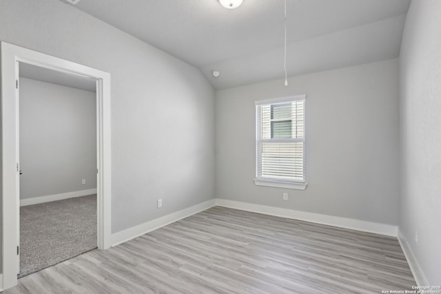 unfurnished room with vaulted ceiling and light hardwood / wood-style flooring