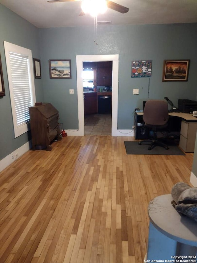 office with light hardwood / wood-style floors and ceiling fan