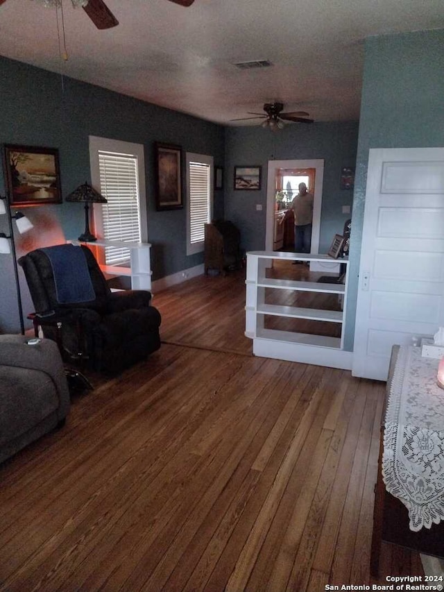 living room with ceiling fan, a textured ceiling, and hardwood / wood-style flooring