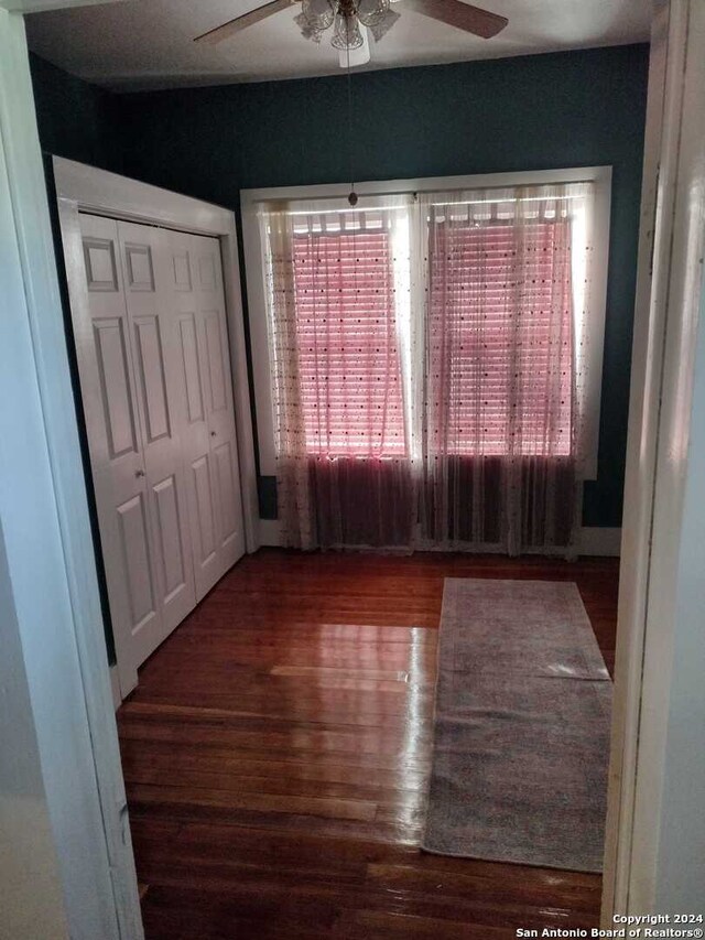 unfurnished room featuring ceiling fan and dark wood-type flooring