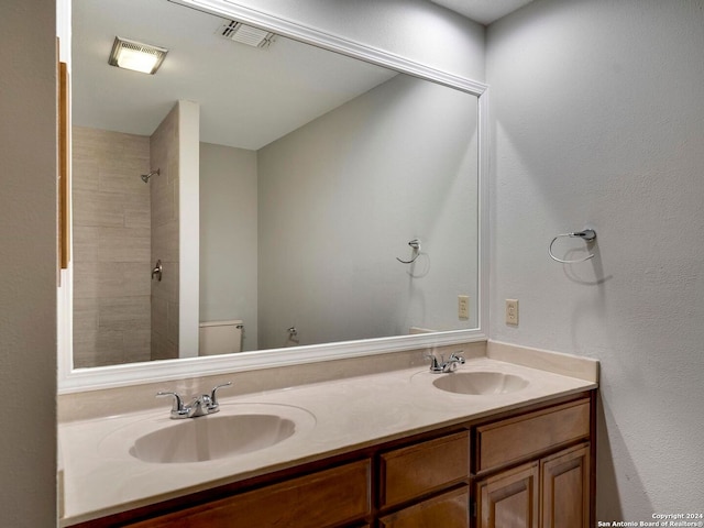 bathroom with double vanity and toilet