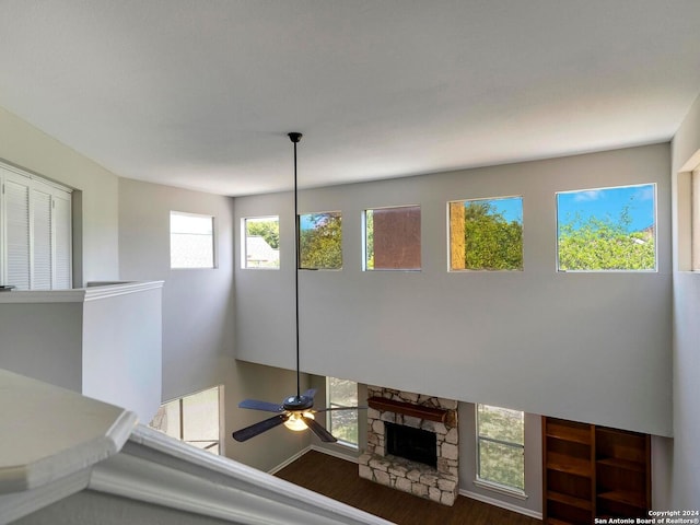 interior space with a fireplace, ceiling fan, and dark hardwood / wood-style floors