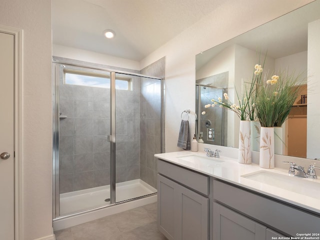 bathroom with tile patterned floors, a shower with door, and vanity