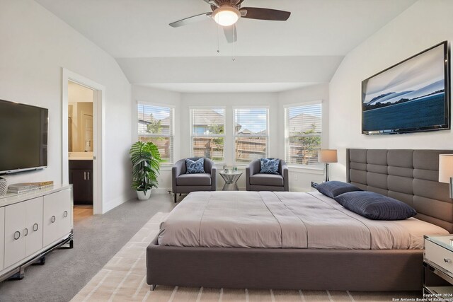 carpeted bedroom featuring vaulted ceiling, ceiling fan, and ensuite bathroom