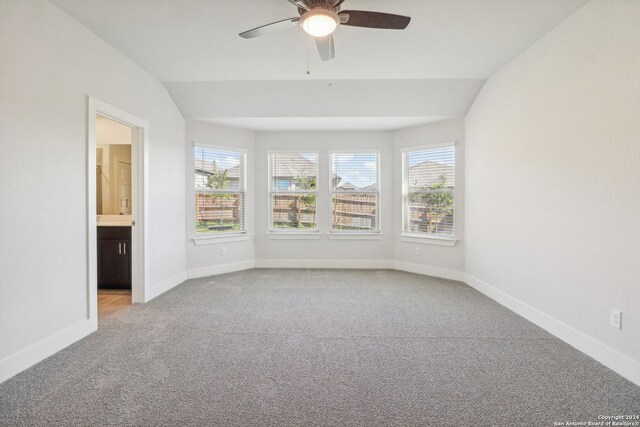 spare room featuring light carpet and vaulted ceiling