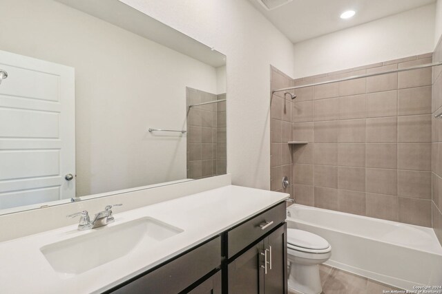 full bathroom featuring vanity, toilet, and tiled shower / bath combo