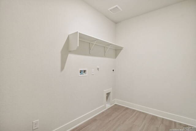 laundry area with gas dryer hookup, hookup for a washing machine, light hardwood / wood-style floors, and hookup for an electric dryer