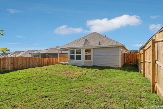 rear view of property featuring a lawn