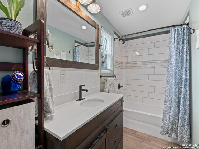 bedroom featuring light hardwood / wood-style floors, ensuite bath, a barn door, and ceiling fan