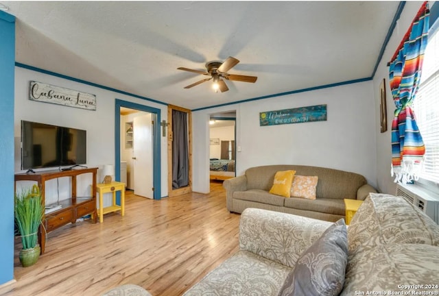 living room featuring light wood-type flooring, ceiling fan, and crown molding