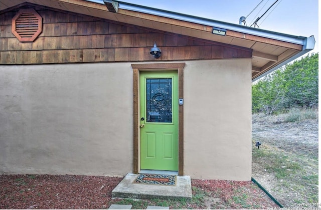 doorway to property featuring stucco siding