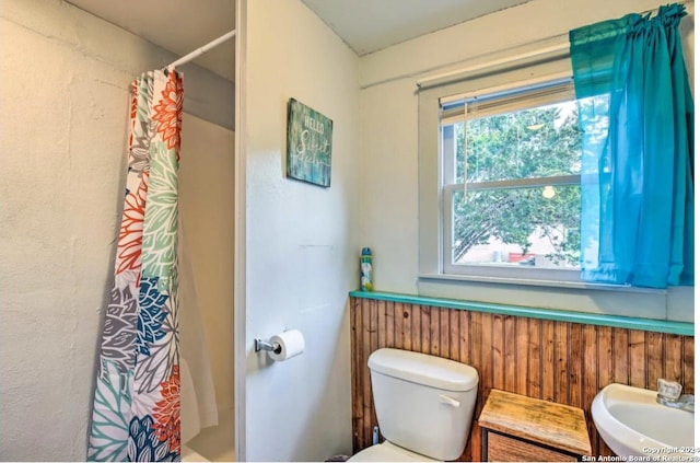 full bath with toilet and a shower with shower curtain