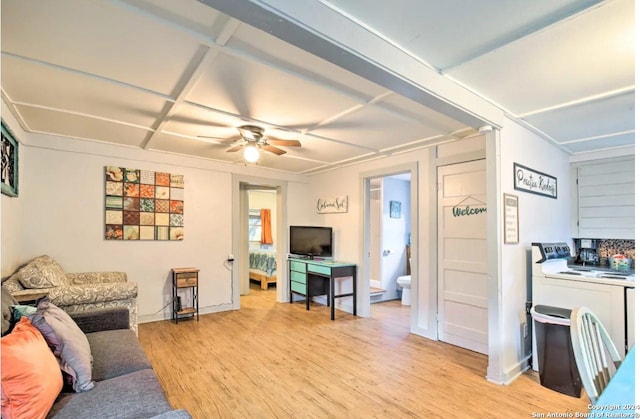 living room with light wood-style flooring, washer / dryer, and a ceiling fan