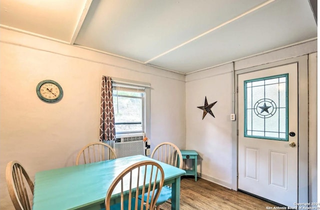 dining space with cooling unit and wood finished floors