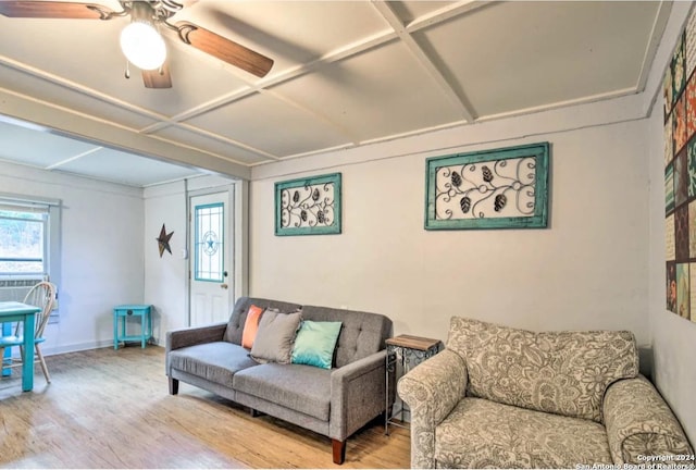 living area with ceiling fan, coffered ceiling, wood finished floors, and baseboards