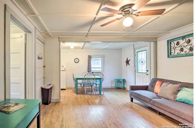 living area featuring ceiling fan, baseboards, and light wood-style floors